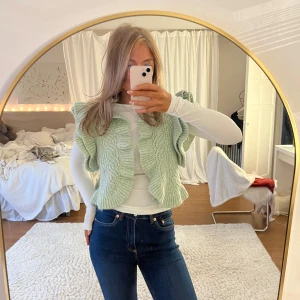 Mintgrön stickad väst - Säljer en söt mintgrön stickad väst med volangdetaljer från Zara 💚