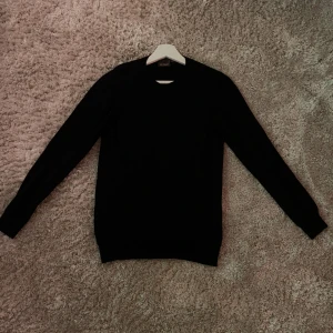 Svart tröja från Oscar Jacobson - Snygg svart tröja från Oscar Jacobson i en klassisk design. Perfekt för en stilren look. Tillverkad i Italien med hög kvalitet. Nypris: 1399, mitt pris: 550