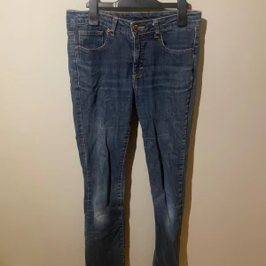 Blå jeans från 365 Sunshine - Snygga blå jeans från 365 Sunshine med klassisk femficksdesign och knappgylf. De har en rak passform och är perfekta för en avslappnad stil. Märkeslappen i brunt läder ger en extra touch.