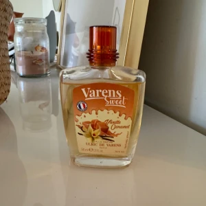 Varens Sweet Vanilla Caramel Parfym - En söt och lockande parfym från Ulric de Varens med doft av vanilj och karamell. Flaskan är genomskinlig med en orange etikett och matchande kork. Perfekt för dig som älskar gourmanddofter.