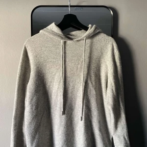 Grå stickad hoodie - Grå kashmir-hoodie - Storlek M Grym hoodie i 100% kashmir i storlek M. Supermjuk och varm, perfekt för när du vill se snygg ut men ändå vara bekväm. Diskret grå färg som funkar till allt. Använd sällan och är i väldigt fint skick.  Perfekt för både vardagsoutfits och lite finare tillfällen!