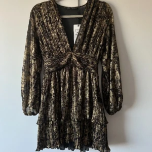 Zara klänning  - Säljer denna superfina svart/guld klänning med dragkedja i sidan från Zara. Säljs inte längre. Helt ny med prislapp, säljer pga fel storlek.💕🌸