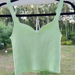 Grönt ribbat linne - Ett grönt ribbat linne från H&M 💚 Linnet är true to size och extremt stretchigt. Passar mig bra som har S i toppar och hade utan tvekan passat till de som bär M också.  Använd 1 gång 💞  Längd: 38 cm Axel: 25 cm