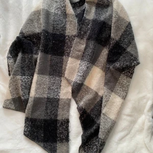 Svart och grå rutig tjockare halsduk från Pieces - Svart och grå rutig tjockare halsduk från Pieces.  Sparsamt använd och i fint begagnat skick.  Kommer från ett djur och rökfritt hem.