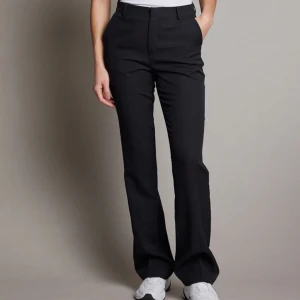 Svarta kostymbyxor - Säljer ett par stilrena svarta Vilma kostymbyxor. Är osäker på om dem är låg eller högmidjadje då dem inte ser högmidjade ut på. Byxorna är i ett bekvämt material. Dem är köpta på bikbok. Använt 2 gånger bara, inga slitage. Kommer inte till användning hos mig. Storlek 36