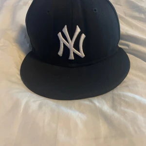 Fitted keps i färgen marinblå - Denna vara är i ny skick pågrund av att denna storleken inte passar mig. St 58,7