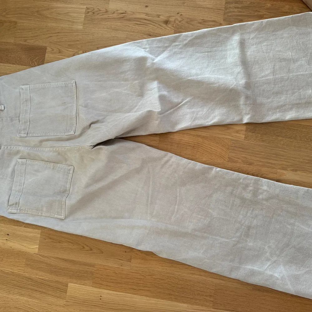 Säljer ett par snygga beige jeans från Zara. De är i en loose passform med hög midja och raka ben. Liten kortare vid anklarna. Byxorna har två stora fickor bak och en enkel knapp framtill.  ”ZARA - The marine straight”. Jeans & Byxor.