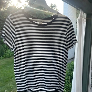 Randig t-shirt från Monki - Säljer en superfin randig t-shirt från Monki. Den är svart och vit med korta ärmar och en klassisk rund hals. Aldrig använd. 