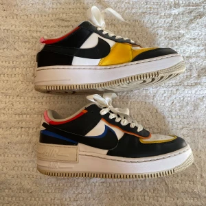 Nike Air Force 1 Low ShadowWhite Black Multi-Color (Women's) - En färgstark och cool sneaker som säljs för mellan 3000-6000 kronor på sneakermarknaden idag. Säljs så billigt pga ett använt skick (se sista bilder, bla hål i ena hälen) går lätt att lappa ihop och använda hur länge som helst! Skosnöre i siden look🤍