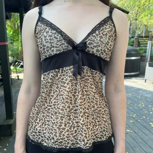 Leopard linne - Jättesnyggt leopard mönstrat linne/topp med fina spetsdetaljer och rosett.  Passar storlek XXS, XS, S och kanske M. 