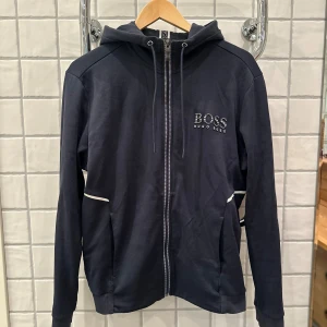 Hugo Boss zipup hoodie - Hugo Boss zipup hoodie i storlek M Skicket är bra förutom på ärmen speciellt på högern (bilder ligger ute med skadorna)  Storlek M och är true to size Skick 7/10