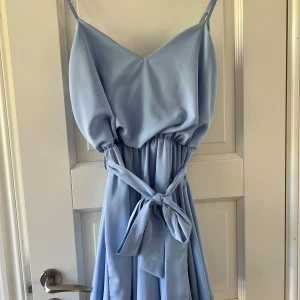 Blå miniklänning - Ljusblå klänning i storlek S som är köpt i Spanien. Inköpspris är 60 Euro! Bra skick , endast använd några fåtal gånger.