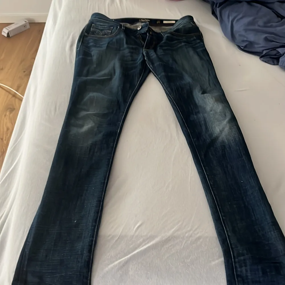 Säljer ett par snygga mörkblå jeans från Replay. De har en klassisk femficksdesign och en cool tvätt som ger dem en avslappnad look. Perfekta för både vardag och fest!. Jeans & Byxor.