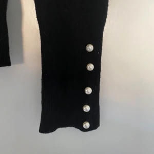 Tröja - Svart tunn stickad långärmad tröja men pärlor längst ut på ärmarna