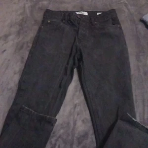 Svarta jeans från FSBN - Säljer ett par svarta jeans från FSBN i storlek 29/30. De har en klassisk design med fem fickor och en knappgylf. Har använts typ 5 eller 4 gånger