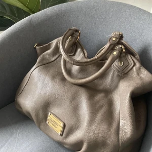 Marc Jacobs vintage väska  - Beige superfin rymlig stor Marc  Jacobs väska. Perfekt till skola och annat! Har fack inuti! De finns tecken på användning med någon bläckfläck inuti men annats är väskan så fin!! Hör av dig för fler frågor! Nypris 7000kr🤗❤️
