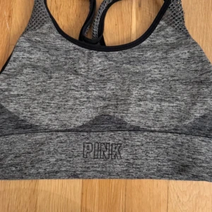 Grå träningstopp  - Grå träningstopp från PINK. Med snygga nätdetaljer på axelbanden. 