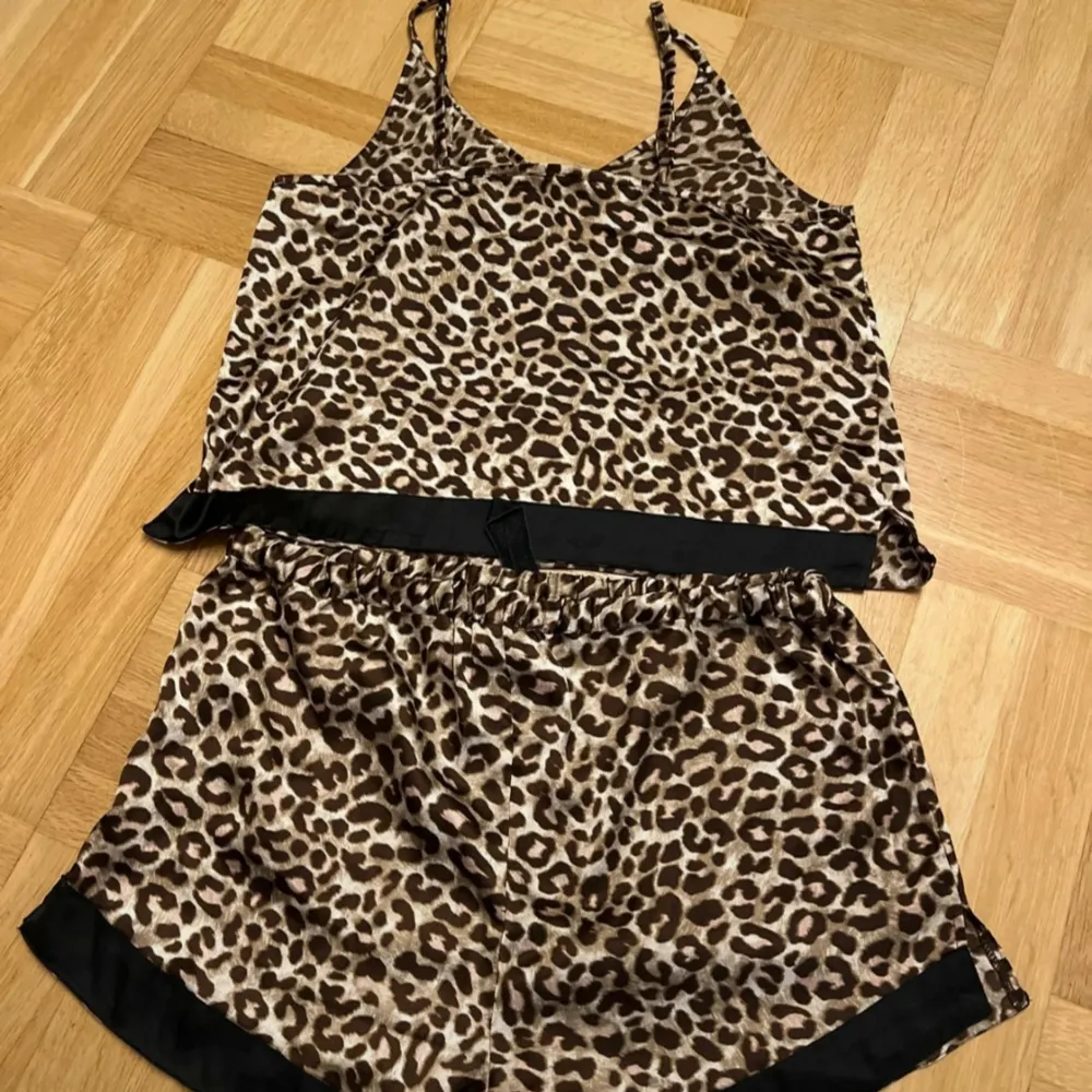 Säljer en superfin leopardmönstrad pyjamas i satin. Setet består av en ärmlös topp med smala reglerbara axelband och matchande shorts. Båda delarna har svarta detaljer vid kanterna. NYTT från Bubbleroom. Storlek M🖤. Övrigt.