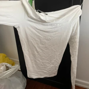 Vit långärmad tröja - Säljer en stilren vit långärmad tröja med en enkel design. Perfekt för en minimalistisk look. Tröjan är i storlek S och har en mjuk och bekväm passform.