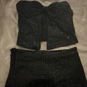 Svart tvådelat sätt. - Svart glittrigt tvådelat sätt i storlek XS men sitter som S, det är shorts i kjolen och anti glid på toppen. Och bara använd en gång 