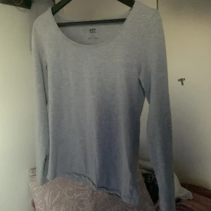 Grå långärmad topp från 157 väldigt tun  - Säljer en stilren grå långärmad topp från 157. Tillverkad i mjuk bomullsblandning med elastan för extra komfort. Perfekt för en avslappnad look. 