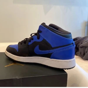 Nike Air Jordans i svart och blått - Snygga Nike Air Jordans i en cool kombination av svart och blått. Säljer för de är för små på mig. PRIS KAN DISKUTERAS!!!
