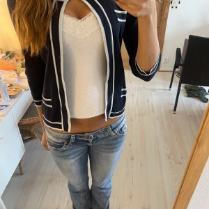 Marinblå kofta med vita detaljer - Snygg marinblå kofta med vita kanter och har en öppen design utan knappar och två fickor fram. Skriv om du har frågor! Pris kan diskuteras vid snabb affär!☺️