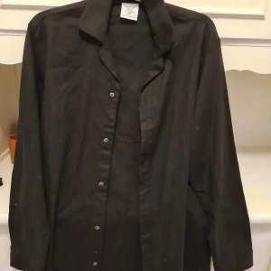 Svart skjorta från Calvin Klein - Säljer en stilren svart skjorta från Calvin Klein. Skjortan har långa ärmar och knappar framtill. Perfekt för en avslappnad och elegant look.