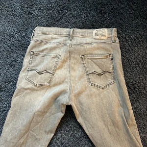 Grå jeans från Replay - Snygga grå jeans från Replay med klassisk femficksdesign och dragkedja i modellen Thad. Snygg grå färg med en straight look.