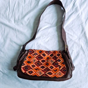 Retro brun handväska med oranget mönster - En super cool brun handväska med 70-tals inspirerat mönster på framsidan. Toppen skick!