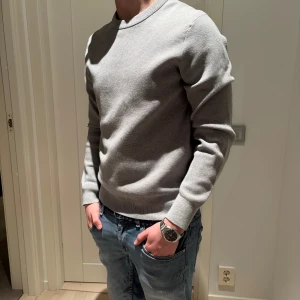 Grå tröja från Uniqlo - Säljer en stilren grå tröja från Uniqlo i storlek S. Tröjan har en klassisk design med rund hals och långa ärmar. Perfekt för en minimalistisk look. Är i storlek s men passar bra på mig som oftast har m. Skriv om ni har frågor eller funderingar 