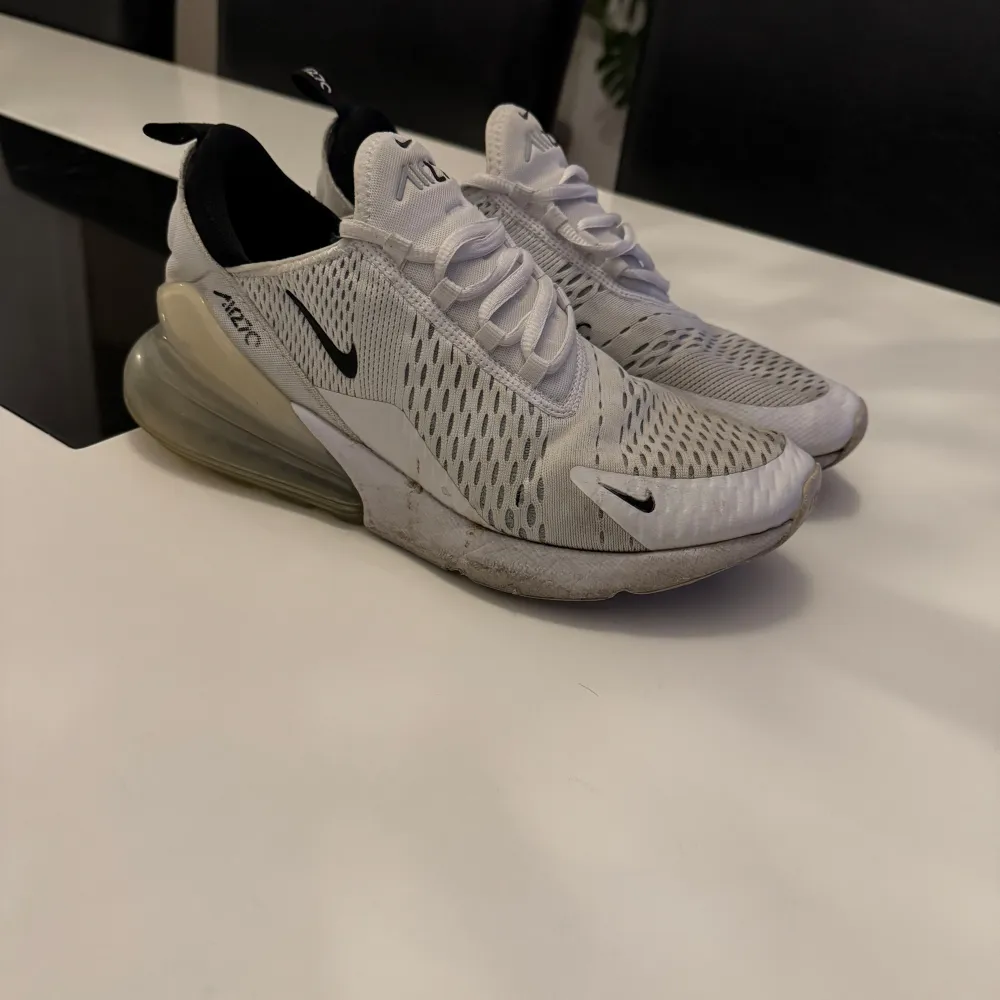 Snygga Nike Air sneakers i vitt och grått med svart detalj. Skorna har en luftig design med snörning och en synlig luftkudde i hälen för extra komfort. Kengät.