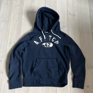 Abercrombie & Fitch Hoodie - Säljer denna riktigt sköna A&F hoodie med snyggt tryck och schyssta slitningar. Storleken är L men sitter som storlek M. Kontakta vid frågor! Prislappen kan diskuteras!