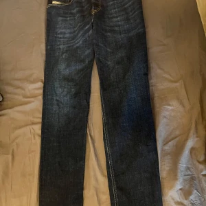 Mörkblå jeans från Diesel - Snygga mörkblå jeans från Diesel med klassisk design och kontrasterande sömmar. Perfekta för en stilren look.Hör av dig vid minsta fundering! Pris ej hugget i sten, väljer du att köpa fler artiklar från min sida kan jag ge ett ett billiga pris👍 finns även på Vinted!. Fraktar inom 48 h W29 L32. helt oanvända 