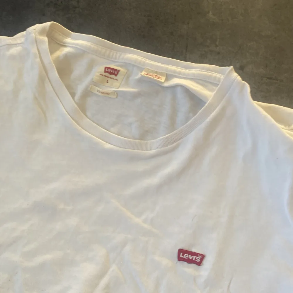 Två klassiska t-shirts från Levi's i svart och vitt. Båda har en liten röd Levi's-logga på bröstet. Perfekta basplagg för garderoben. Tillverkade i mjuk bomull för en bekväm passform.. T-paidat.