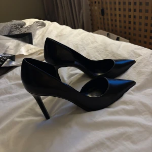 Svarta pumps - Eleganta svarta pumps från Mango med spetsig tå och en klack på 10cm. Strl 38 men stora i storlek så tyvärr för stora. Endast testade, nypris 529kr