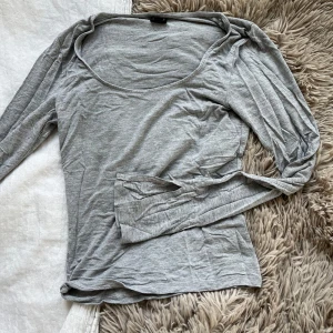 Grå topp med slit - GinaTricots ”soft touch jersey top” i grå. Väldigt skönt material. 