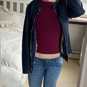 Mörkblå skinnjacka - Säljer en stilren mörkblå skinnjacka med dragkedja framtill. Jackan har en klassisk design med långa ärmar och en rak passform. Perfekt för att ge en cool touch till din outfit. Storlek 2xl men jag tycker den sitter som 2xl. Skriv för fler foton.  Utsidan är 100% PU/PU. 