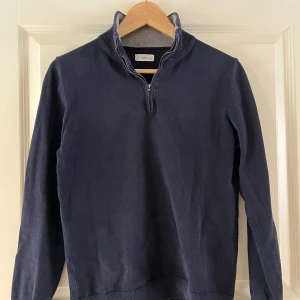 Mörkblå tröja half-zip från MNG - Säljer en stilren mörkblå tröja från MNG half-zip. Tröjan har långa ärmar och ribbade detaljer vid krage och ärmslut. Perfekt för en avslappnad och snygg look. Kontakta ifall frågor