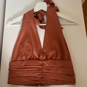 Festtopp - Fin topp från Bikbok i storlek Small i en fin typ rostfärg. Använd fåtal gånger