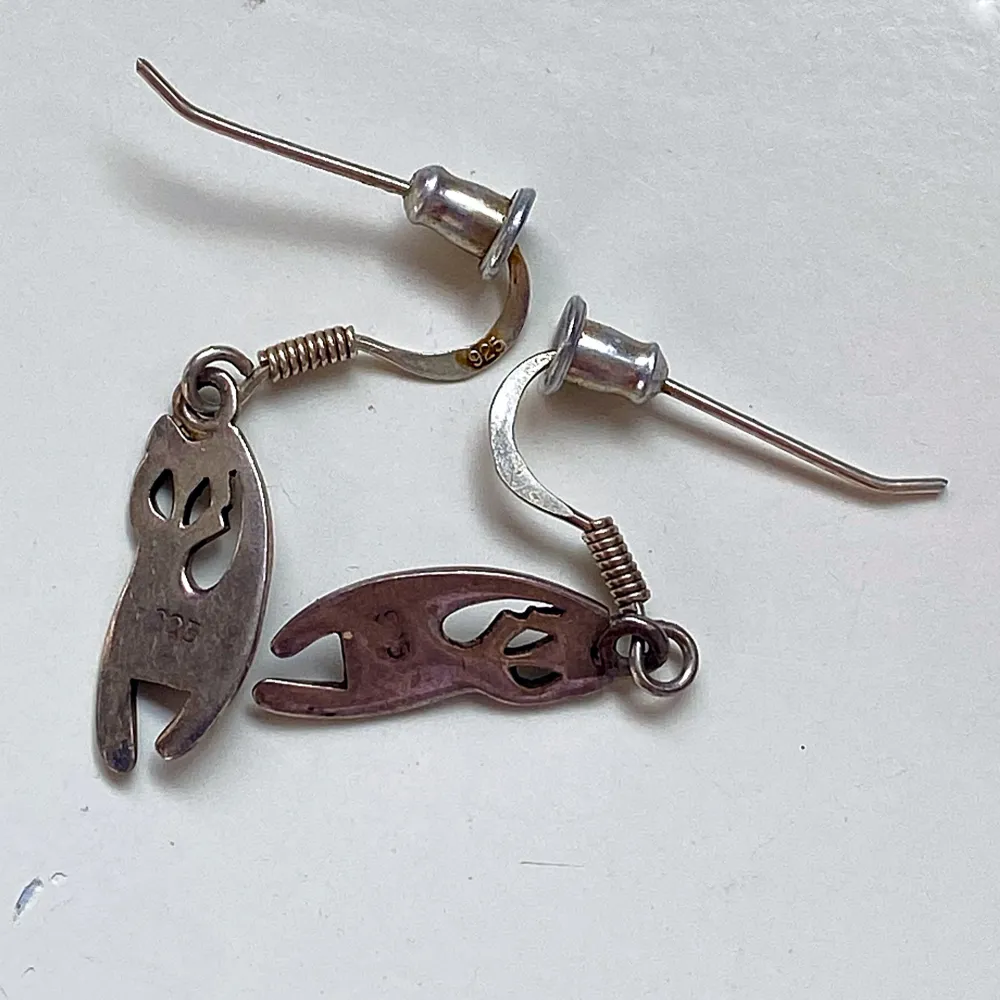 Säljer ett par coola örhängen i silver med ett unikt kattmotiv. De är små och lätta, perfekta för dagligt bruk eller för att ge en subtil touch till din outfit. Örhängena är märkta med 925, vilket betyder att de är i äkta silver. De har en krokdesign som gör dem enkla att sätta i och ta ur. Perfekta för kattälskare eller för den som gillar unika smycken!. Asusteet.
