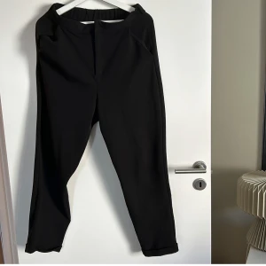 Svarta byxor från Bik Bok - Säljer ett par svarta byxor från Bik Bok i storlek M. De är stilrena och passar perfekt för både vardag och fest. Byxorna har en elastisk midja för extra komfort och två bakfickor som ger en snygg detalj. Perfekta att matcha med en snygg topp eller blus!