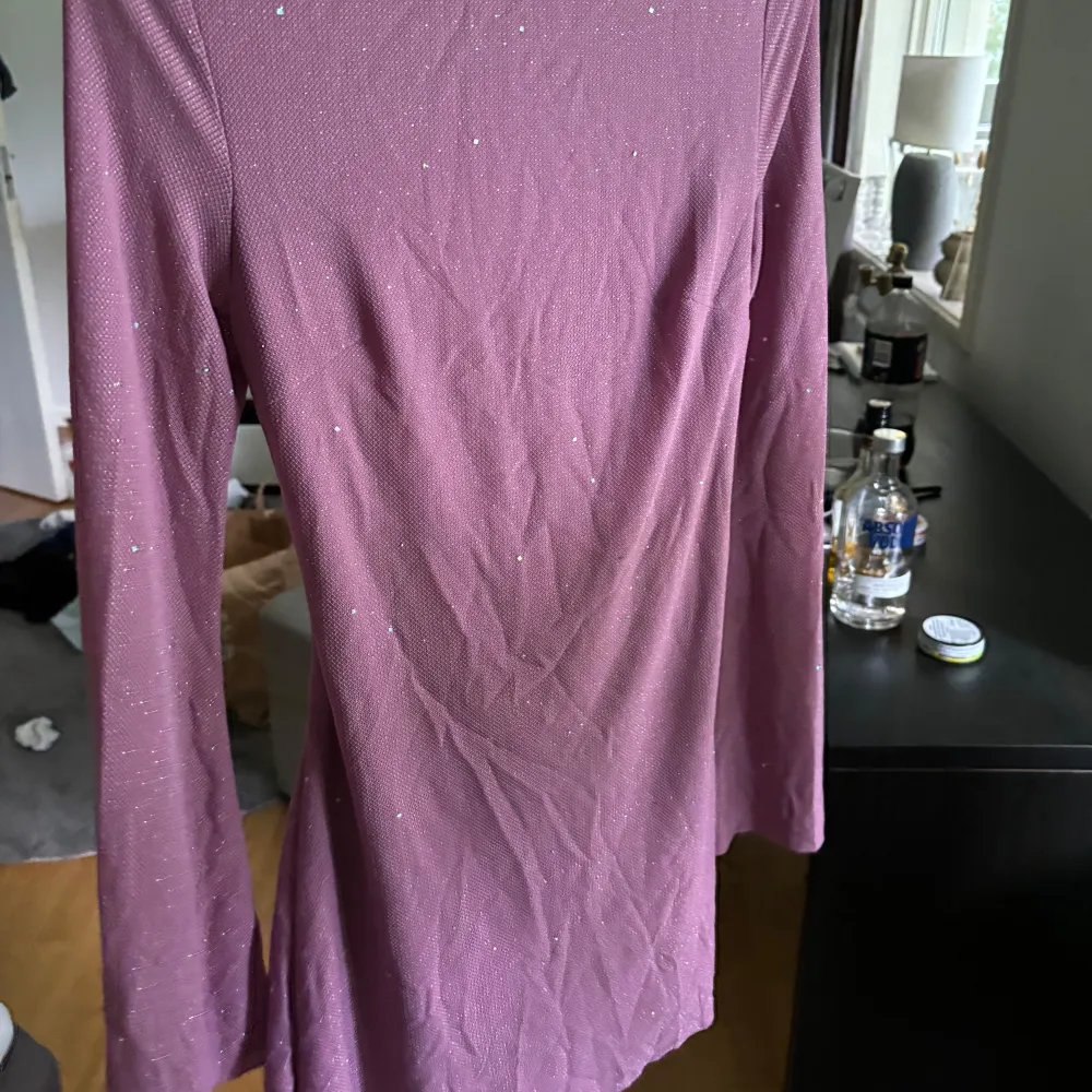 En lila glitter klänning som är nästan oanvänd . Mekot.
