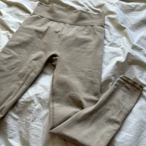 Träningstights  - Beiga träningstights i ribbat material. Höga i midjan. Knappt använda.