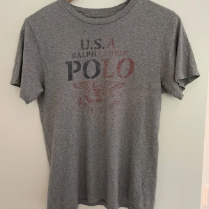 Ralph Lauren T-shirt - Ralph Lauren T-shorts Grå med tryck  Storlek: S/M  Säljer nu denna Gråa Ralph Lauren tishan med schysst Polo tryck då den är för liten för mig.