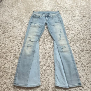 Ljusblå bootcut jeans - Snygga ljusblå bootcut jeans med slitna detaljer. De har en låg midja och klassisk femficksdesign. Omsydda till bootcut. Skriv om ni har frågor 💓