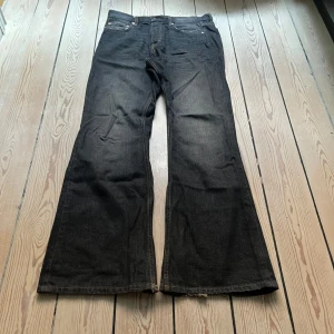 Weekday Bootcut - Svarta urtvättade bootcut jeans ifrån Weekday! oversized passform, Storlek: W28 L34. Gott skick! Mått: Längd 111cm, Midja 41cm, benöppning 29cm. Möts upp på Södermalm, använd gärna "köp nu"