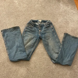 Lågmidjade blå bootcut jeans  - Snygga blå jeans med knappar. Lågmidjade bootcut och sitter helt perfekt. Rekommenderar för dig som vill uppgradera din garderob. Strl 152. Säljer för de är för små men är otroligt fina! 