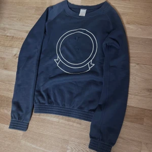 Number (n)ine AW01 Shield sweatshirt - AW01 ”Standards” Number (n)ine Sweatshirt, Ovanlig piece som säljs sällan. Blå linje tag enbart för den blåa shield sweatshirten och hoodien. Tröjan har hål på fram och bak sidan, alltså från produktions processen. Designad av Takahiro miyashita som senare lämnade märket 2009. Äkta, Kvaliteten är omatchad med bomull inköpt från Italien. Obs skriv om du är intresserad. *** kan tidigast skicka 20 Jan.