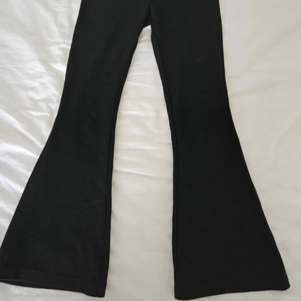 Snygga svarta bootcut byxor med hög midja. Perfekta för en stilren look. Tillverkade i ett stretchigt material för extra komfort. Helt nya och oanvända . Farkut & Housut.
